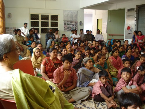 Dr. Shantuben (seated) and the parents and children watching and listening during the storytelling workshop.