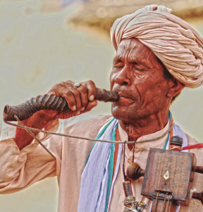 Babunath Jogi, a devotional vocalist, plays the Jogia Sarangi and sings eulogies and folktales with his co-artists Surdas and Mehmood khan who accom- pany with the beats of Bhapang (rare single stringed percussion instrument) and the Dholak.