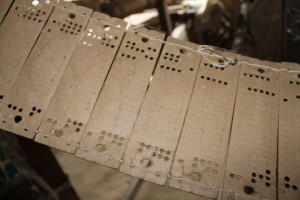 The rectangular cardboard with digital punched holes that somehow give rise to the patterns