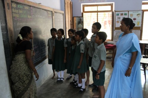 Principal, monitoring the children pronouncing the words, in an Tamil Speaking session