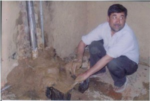 Mr Vidya Rattan Sharma making a cookstove in a kitchen