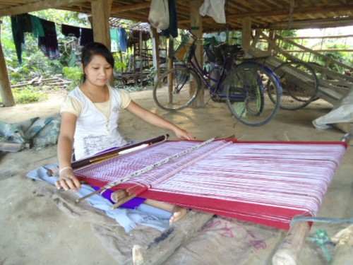 A woman from the Chamka tribe weaving outside her home.