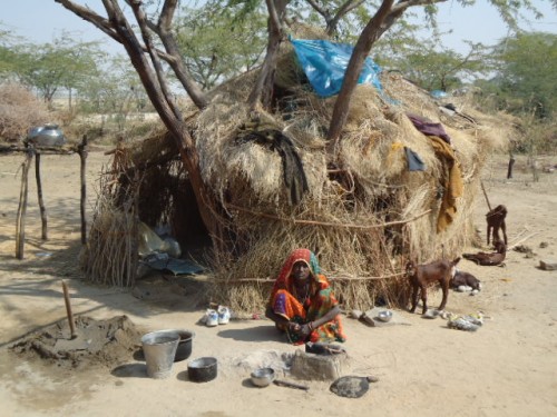A Bagaria woman outside her hut of baked mud and thorny branches