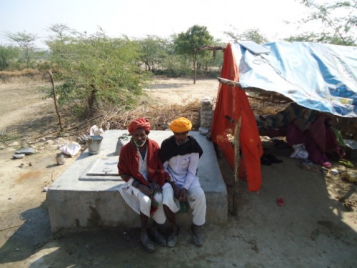 Bagariya men sitting outside their hut. Most of them own no more than a small parcel of land, compelling them to work as lowly-paid labourers or as guards in other people’s fields.