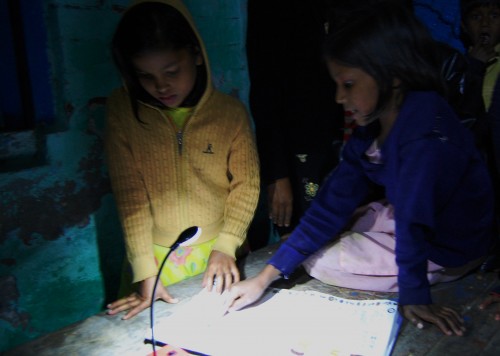 Girls studying using a solar light