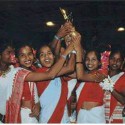 The 18 girls in their traditional attire, lifting the trophy at Victoria Gastiez, Spain