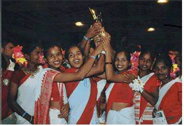 The 18 girls in their traditional attire, lifting the trophy at Victoria Gastiez, Spain