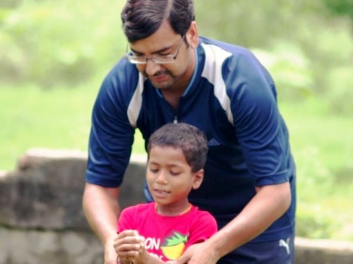 Founder, Akshai Abraham, teaching under hand to a beneficiary, during a volleyball session