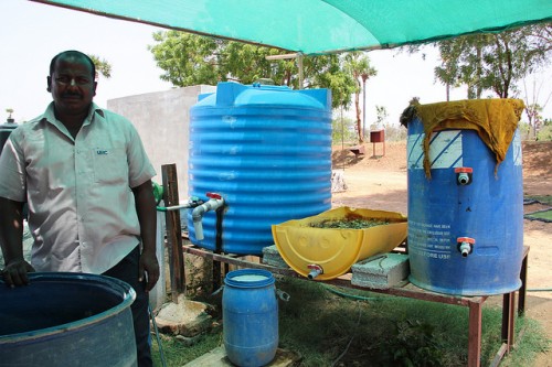 Alagesan with the barrel used to ferment cow dung