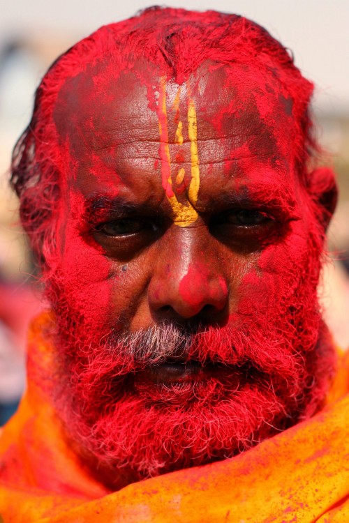 A temple priest bathed in red gulaal takes time out to pose for the camera.