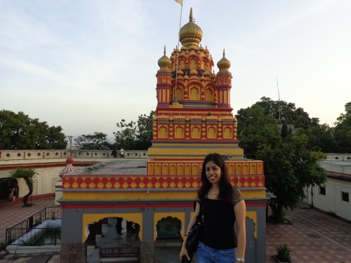 The writer standing against the façade of the Parvati temple