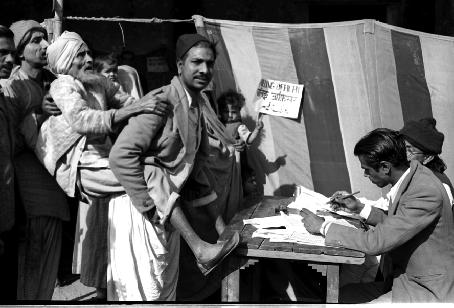 A blind old man being carried towards a polling booth by his son, to help him to cast his vote, near a polling station in Jama Masjid area in Delhi.