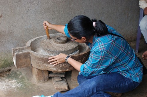 A city girl trying her hand at grinding rice