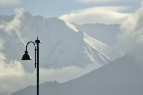 View of a streetlight against snowy mountains outside KBR Airport, Leh.