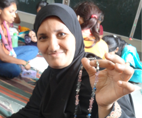 A woman shows the jewellery she made for the very first time in the training organised by Srujna