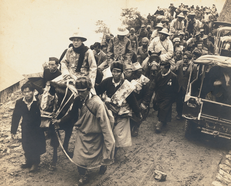 The Dalai Lama in ceremonial dress enters India through a high mountain pass. He is followed by the Panchen Lama, Sikkim, India; 1956 Gelatin Silver Print From the exhibition: Candid: The Lens and Life of Homai Vyarawalla Collection: Alkazi Collection of Photography Image Courtesy: Rubin Museum of Art, New York ​