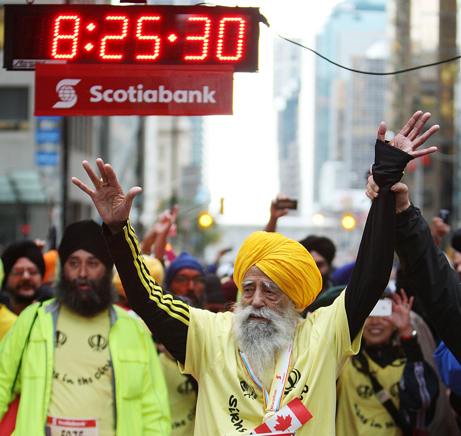 Fauja Singh waves to supporters minutes after finishing the 2011 Toronto Scotiabank Marathon