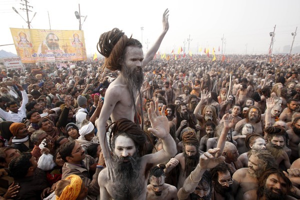 EDS NOTE; NUDITY - Naked Hindu holy men or a Naga Sadhus return to their camp after a dip at Sangam, the confluence of the Rivers Ganges, Yamuna and mythical Saraswati on one of the most auspicious day Makar Sankranti, the first day of the Maha Kumbh Mela, in Allahabad, India, Monday, Jan. 14, 2013. Millions of Hindu pilgrims are expected to take part in the large religious congregation of a period of over a month on the banks of Sangam during the Maha Kumbh Mela in January 2013, which falls every 12th year, where devotees wash themselves in the waters of the Ganges believing that it washes away their sins and ends the process of reincarnation. (AP Photo /Rajesh Kumar Singh)