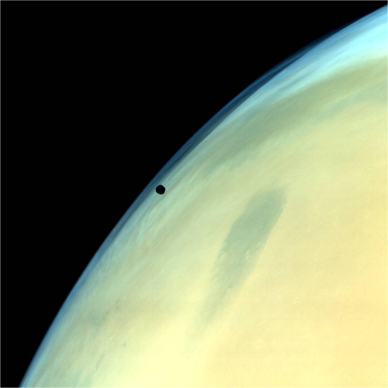 Phobos, one of the two natural satellites of Mars silhouetted against the Martian surface