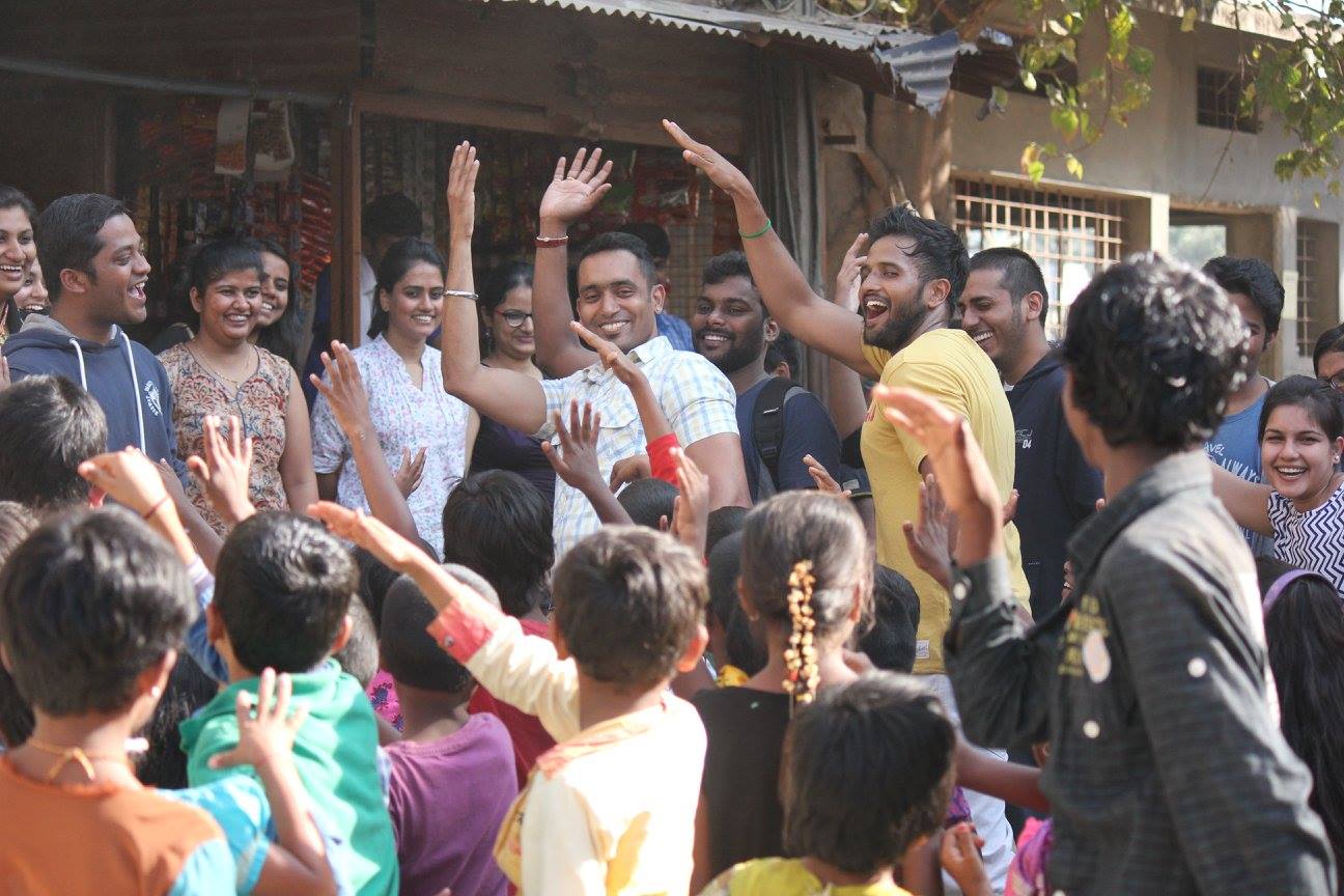 Volunteers dancing with children during the food drive