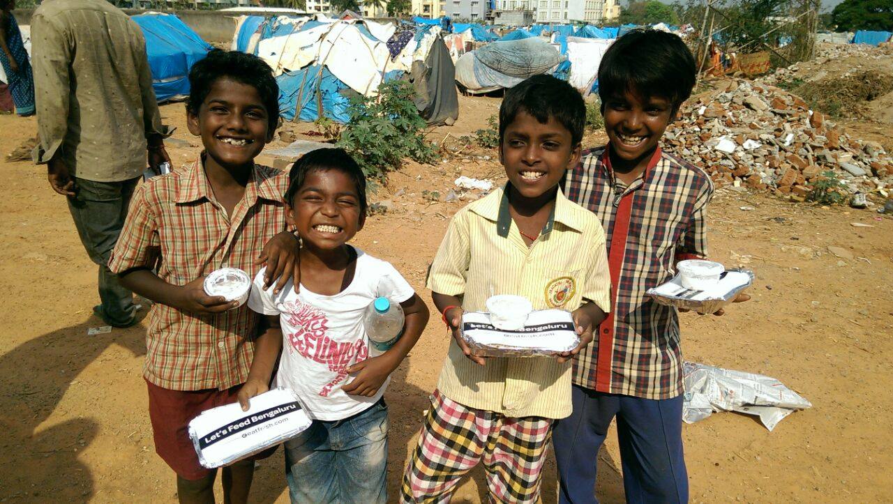 Happy children with food packets from Let's Feed Bengaluru