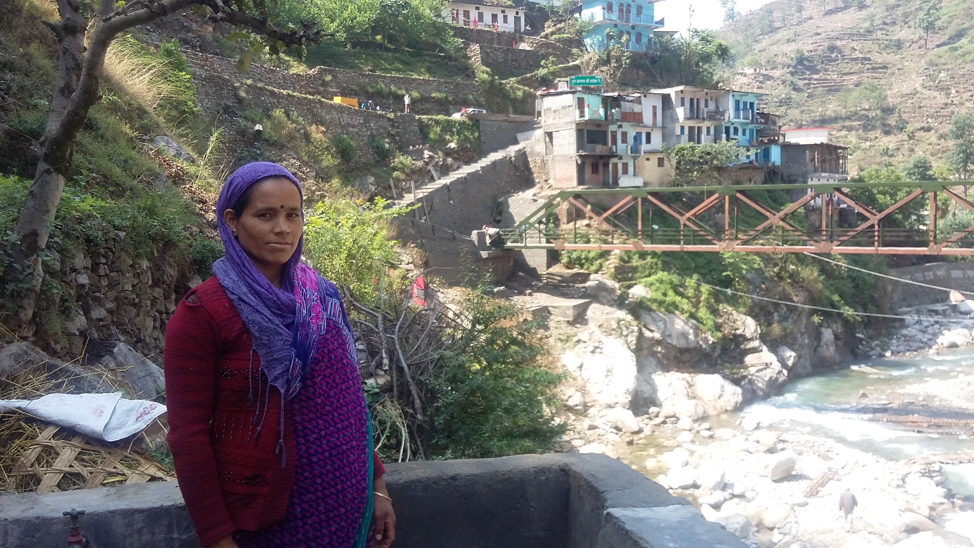  Although Vimla has managed to rebuild her home and the shop she is still waiting for the bridge (in the background) that connects the two to be repaired. (Credit: Nitin Jugran Bahuguna\WFS)