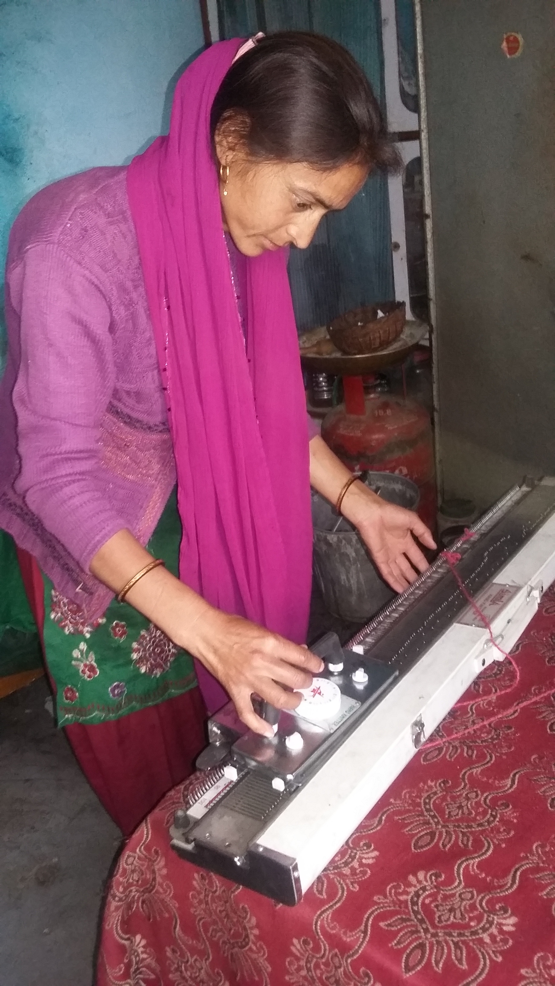 Gita Bisht, 33, of Chandrapuri, widowed in 2013, sees her knitting machine as the means to a better life someday. (Credit: Nitin Jugran Bahuguna\WFS)