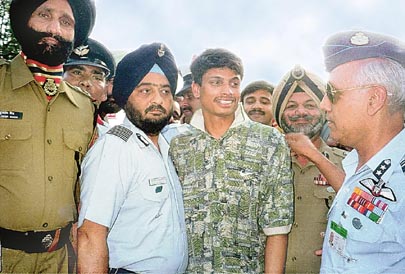 Flight Lieutenant K. Nachiketa, center, is received by Indian Air Force Vice Air Marshall Shashi K. Tyagi, right, at the Wagah border crossing between India and Pakistan Friday June 4, 1999. Flt.Lt. Nachiketa, a pilot in the Indian Air Force, was captured after ejecting from his aircraft during a mission over the disputed Kashmir region. He was released on Thursday in Pakistan but after visa delays made it to the India border on Friday. (AP Photo/Deepak Sharma)