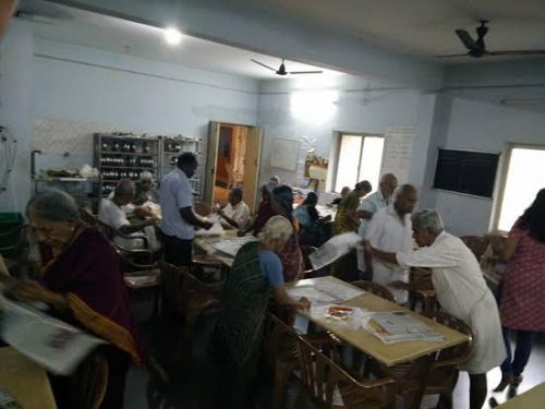 Senior citizens of Anandam Old Age Home distribute food packets during the Chennai floods.
