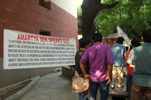 Image of some students walking with back towards the camera. On left hand side is a white banner saying Amarta Sen speaks out and has an excerpt of his letter.
