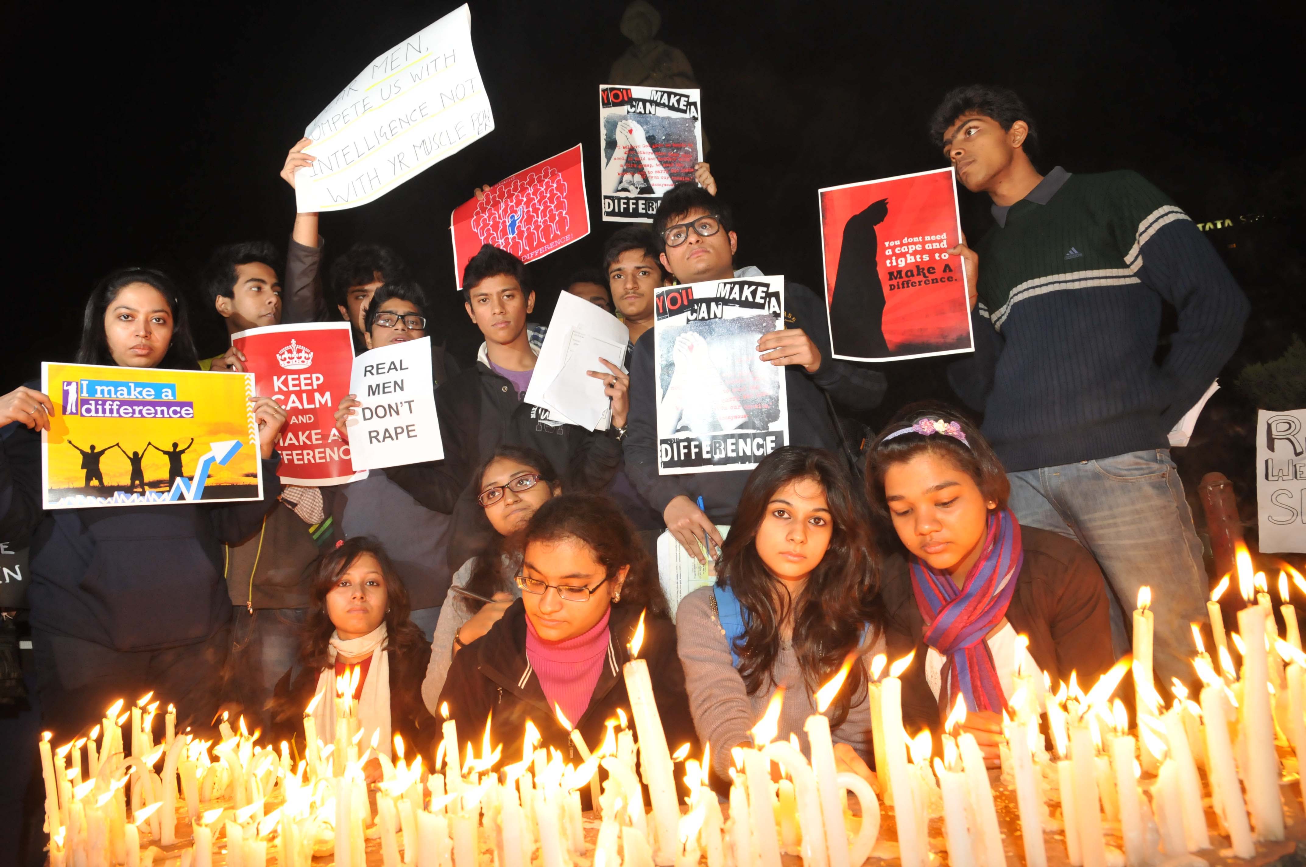 An Indian College studens candel light and protestor holds a placard at front of Former PM of India Indira Gandhi Statute during a protest demanding better security for women in Kolkata on December 29, 2012, after the death of a gangrape victim from the Indian capital New Delhi. Indian leaders appealed for calm and security forces headed off fresh unrest by turning New Delhi into a fortress after a student who was savagely gang-raped died in a Singapore hospital. Police threw a ring of steel around the centre of the Indian capital after news of the 23-year-old medical student's death was broken in the early hours by the Singapore hospital .that had been treating her for the last two days. Photo by Debajyoti Chakraborty,Kolkata,India.