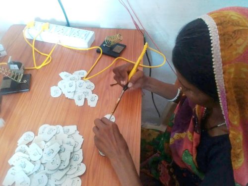 Tribal women like Rukmini are now familiar with all the parts of the portable solar lamp that they assemble efficiently. (Credit: Renu Rakesh\WFS)