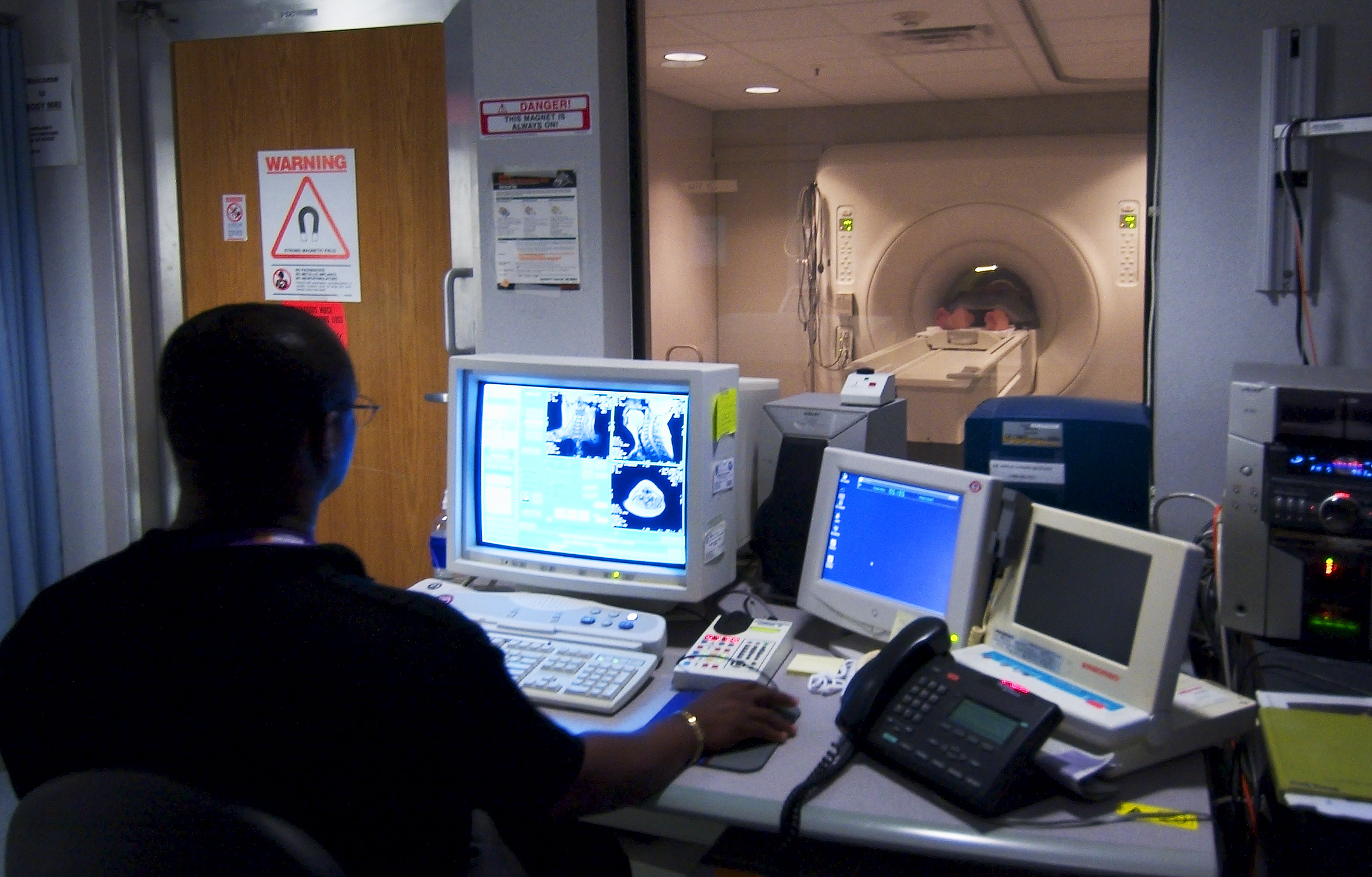 030819-N-9593R-228 National Naval Medical Center, Bethesda, Md., (Aug. 19, 2003) -- Civilian technician, Jose Araujo watches as a patient goes through a Magnetic Resonance Imaging, (MRI) machine at the National Naval Medical Center in Bethesda, Maryland. U.S.Navy photo by Chief Warrant Officer 4 Seth Rossman. (RELEASED)