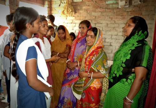 Nisha and her friends speak with women from their community