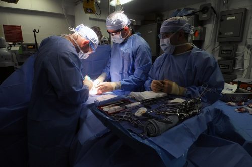 110824-N-JD217-053 ARABIAN SEA (Aug. 24, 2011) Lt. Matthew J. Bradley, left, and Lt. Cmdr. John R. Balentine, center, perform an umbilical hernia repair while Hospital Corpsman 3rd Class David L. Cumpian assists in the operating room aboard the aircraft carrier USS George H.W. Bush (CVN 77). George H.W. Bush is deployed to the U.S. 5th Fleet area of responsibility on its first operational deployment conducting maritime security operations and support missions as part of Operations Enduring Freedom and New Dawn. (U.S. Navy photo by Mass Communication Specialist Seaman Jessica Echerri/Released)