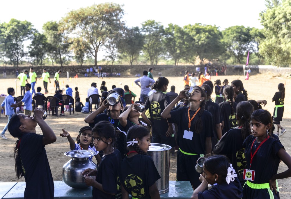 Girls takes break during a friendly football match, in Meeno Ka Naya Gaon. Water fetched by girls themselves before the match.