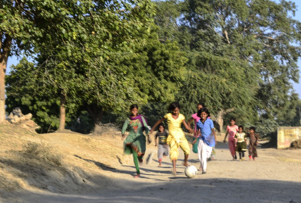 12 — year — old and Students of 6th class, Monica and Pratibha along with others chasing the ball on the way to ground, in Sakariya.