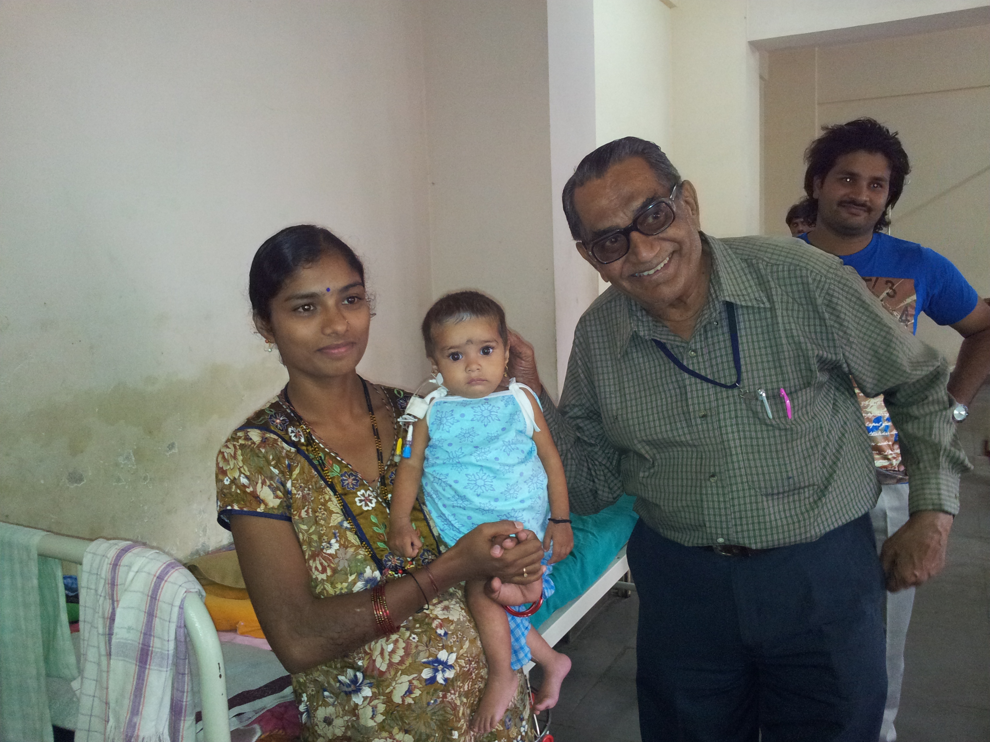 Ramaswamy with a mother and child in a hospital