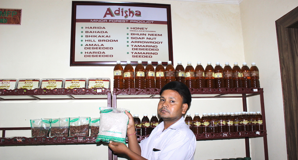 At a Bhubaneswar government outlet for minor forest products, a shop assistant holds up their fastest moving item, the powdered millet packet, whose sale has doubled in the last year. (Photo by Manipadma Jena)