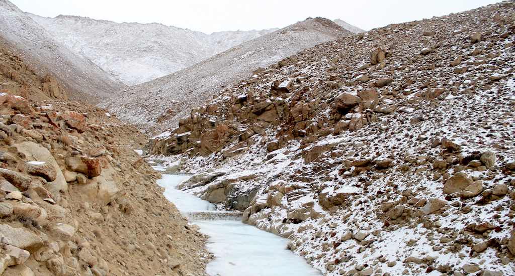 Water blocked by an embankment begins to freeze in December, forming an artificial glacier. (Photo by Samten Choephel)