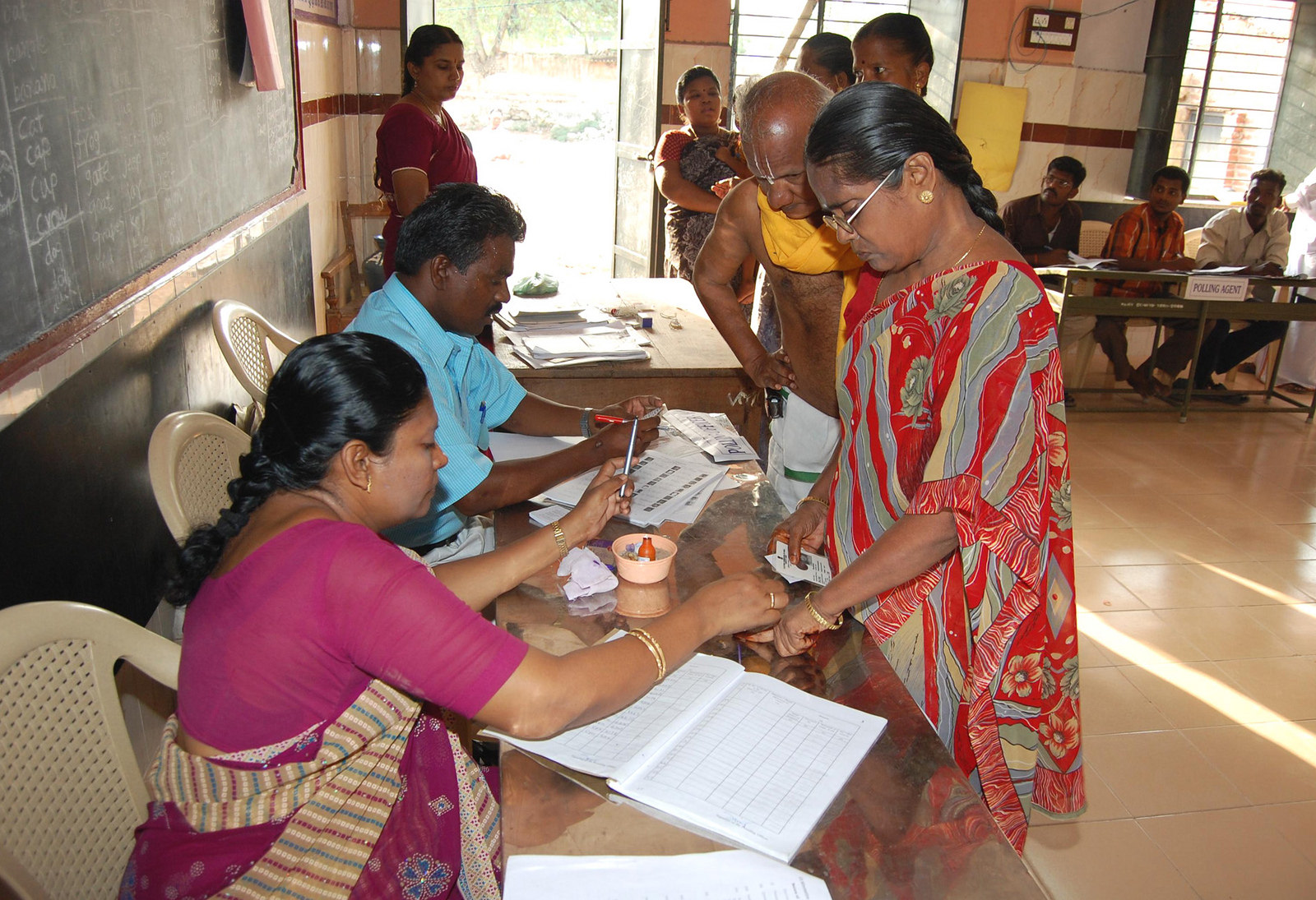 Polling officer administering indelible ink at the finger of a female voter at a polling booth. (Source: Flickr/Public.Resource.Org)
