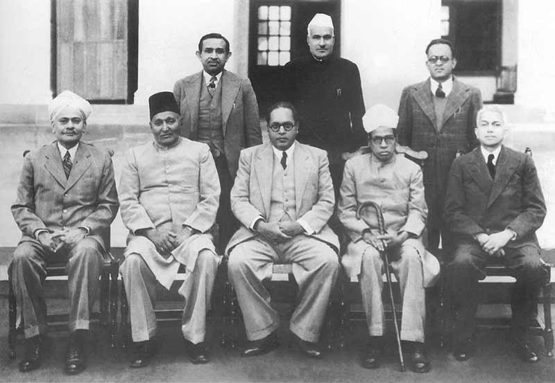 (Sitting from left) N. Madhavrao, Sayyad Sadulla, BR Ambedkar (Chairman), Alladi Krishnaswamy Iyer, Sir Benegal, Narsingh Rao. Standing from left – S.N. Mukharjee, Jugal Kishor Khanna & Kewal Krishnan. (Source: Twitter/Prashant Shrivastava) 