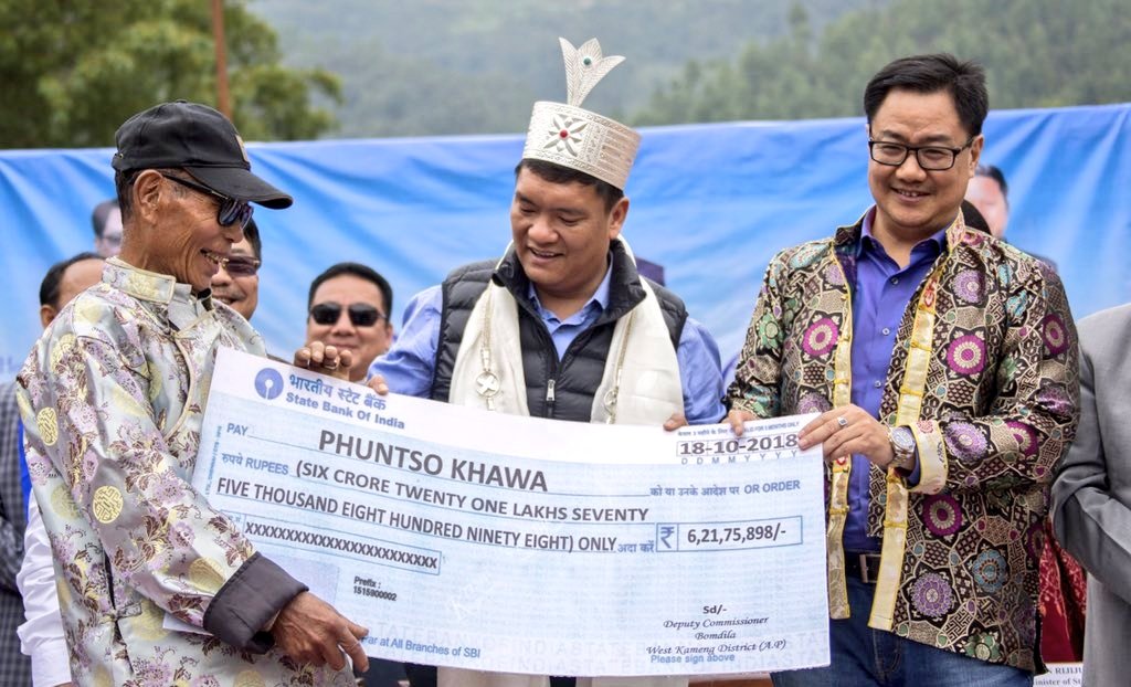 A local resident receiving a cheque from Chief Minister Pema Khandu and MoS (Home) Kiren Rijiju. (Source: Twitter/Kiren Rijiju)