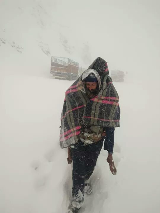 A Police constable carrying ailing truck driver trapped in snow on his back during rescue operation in Mughal road. (Source: Twitter/J&K Police/Amit Sharma)