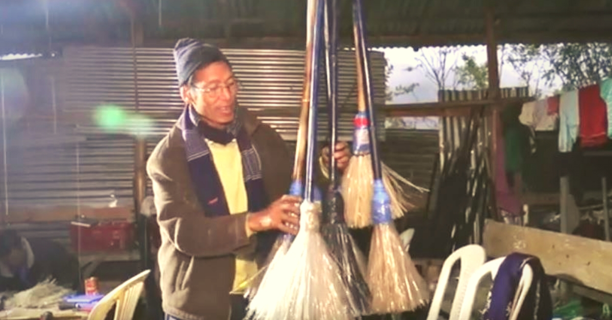 Usham Krishna Singh standing with his brooms made of plastic bottles. (Source: YouTube)