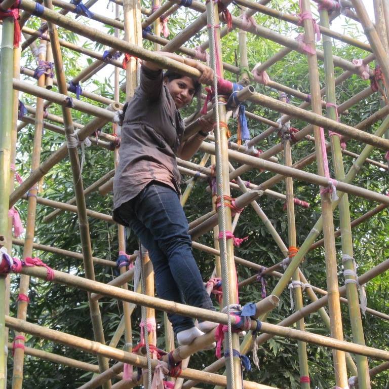 Purnima Barman climbing up a bamboo structure to observe the Greater Adjutant Stork. (Source: Facebook)