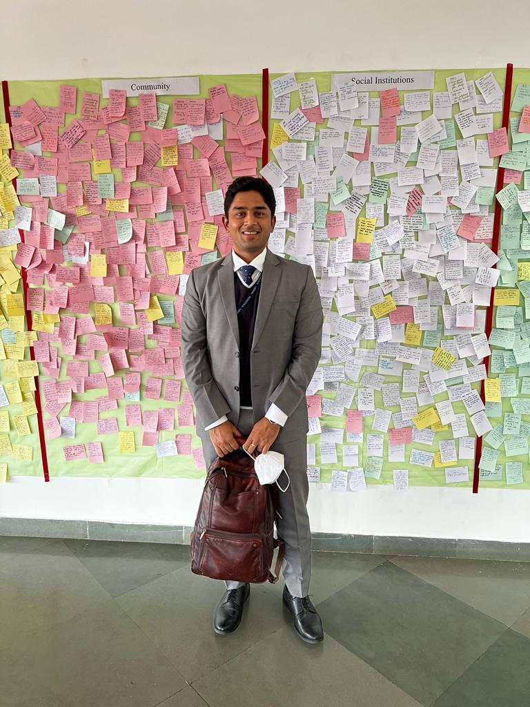 IAS officer prateek rao standing in the academy flanked by post-its. Essay high scorer.