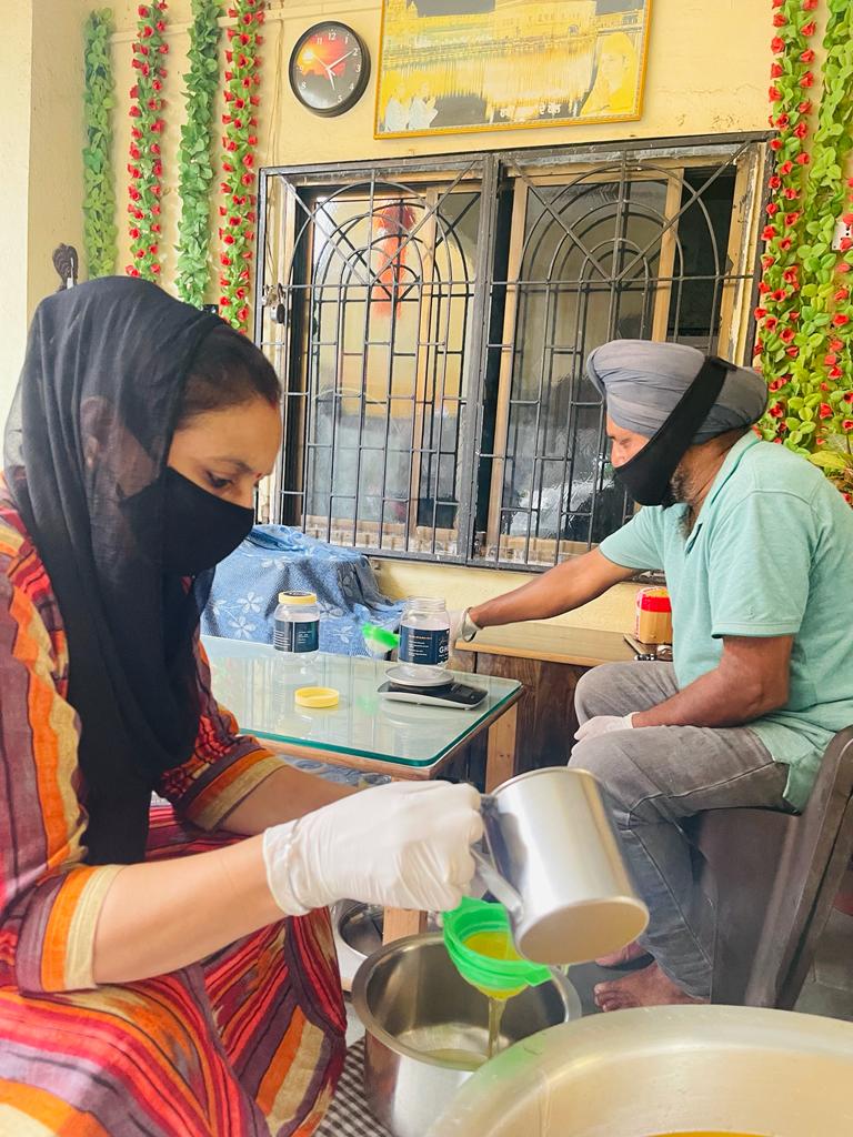 Kamaljit Kaur and her husband pouring the ghee into containers - ready to be shipped. 