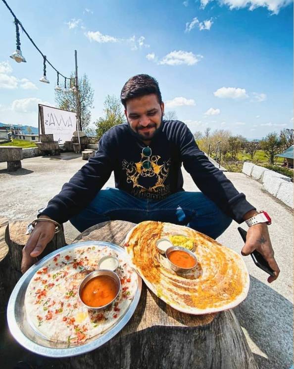 A man sitting in Bir and looking at the food. 