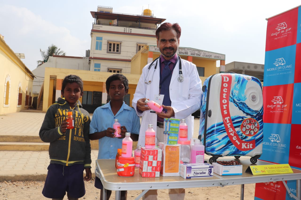 A doctor with two children at a medical camp.